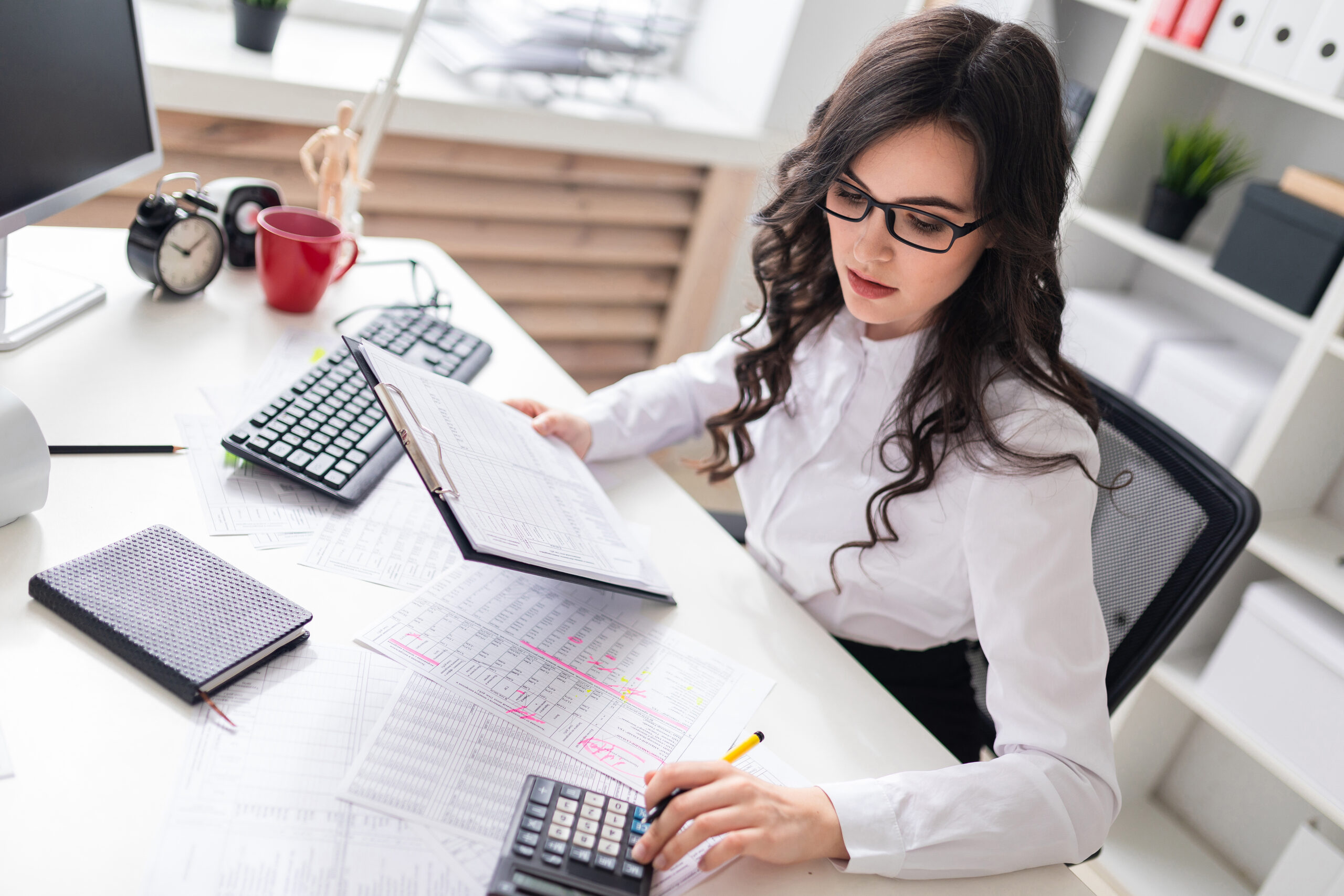 A charming young girl is working in a bright office. photo with depth of field.